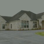 Stone exterior and driveway of Needville Cottage, a small assisted living home in Needville, Texas