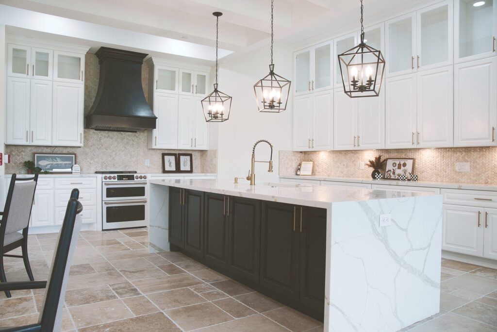 Home kitchen with white cabinets and a marble island where meals are cooked at Village Forest Needville